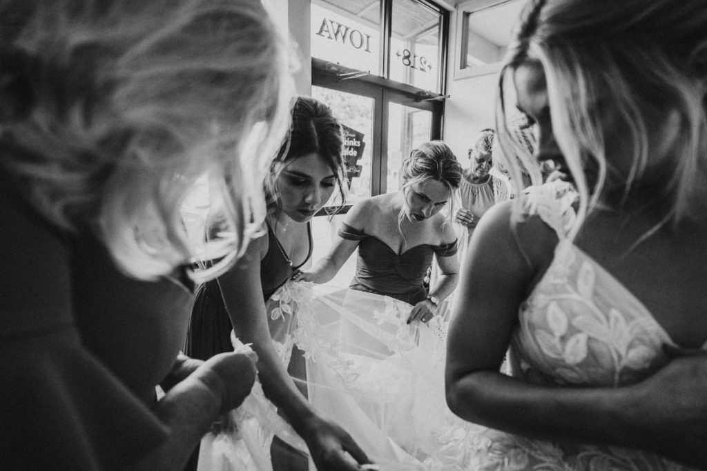 helping bride bustle her dress