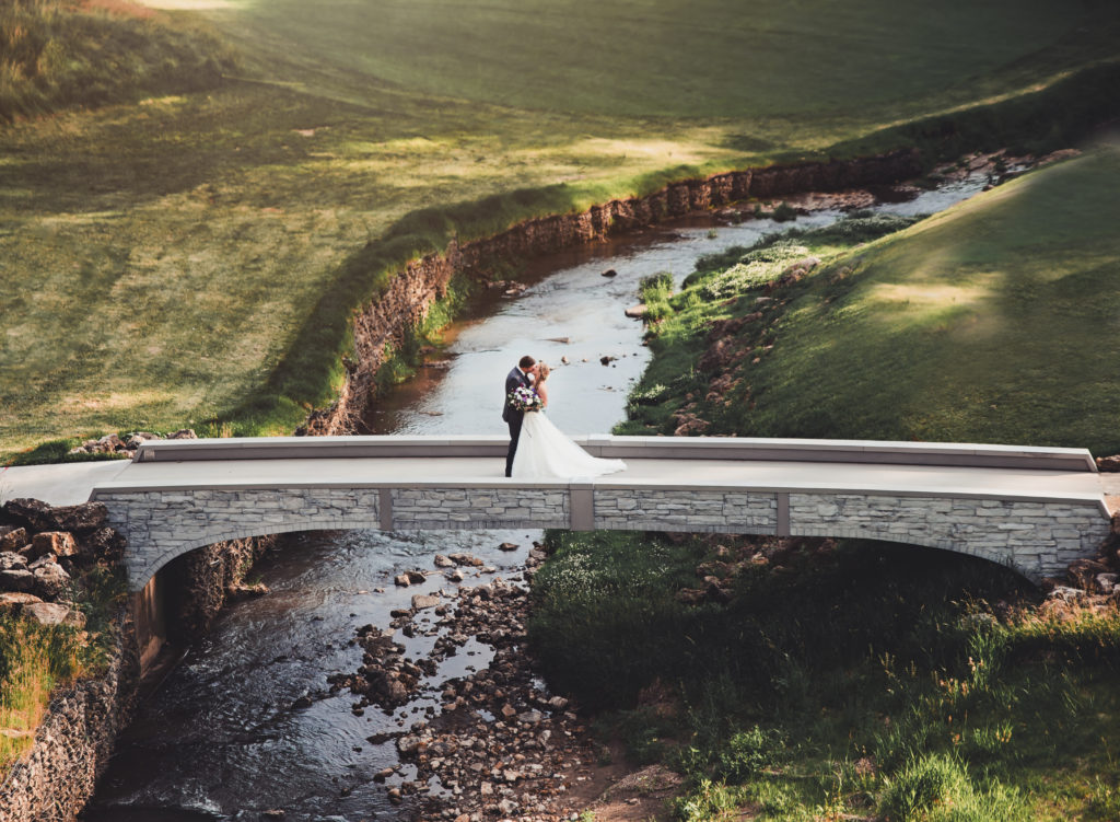 bride and groom on bridge