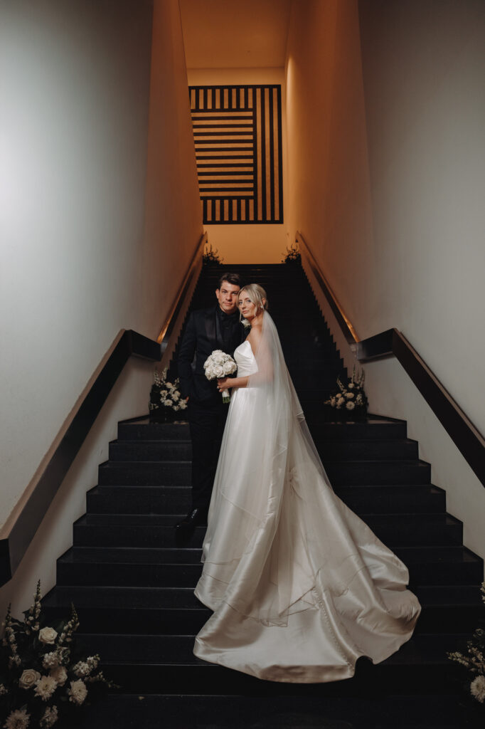 bride and groom in an editorial photo on the steps inside the Figge Museum